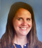 Woman smiling posing for portrait photograph against blue background.