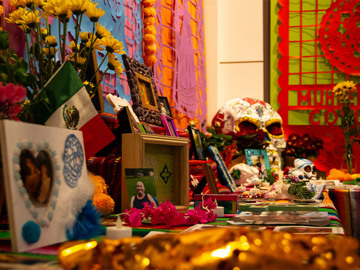 A colorful altar celebrating Dia de Los Muertos features photos and momentos from loved ones.