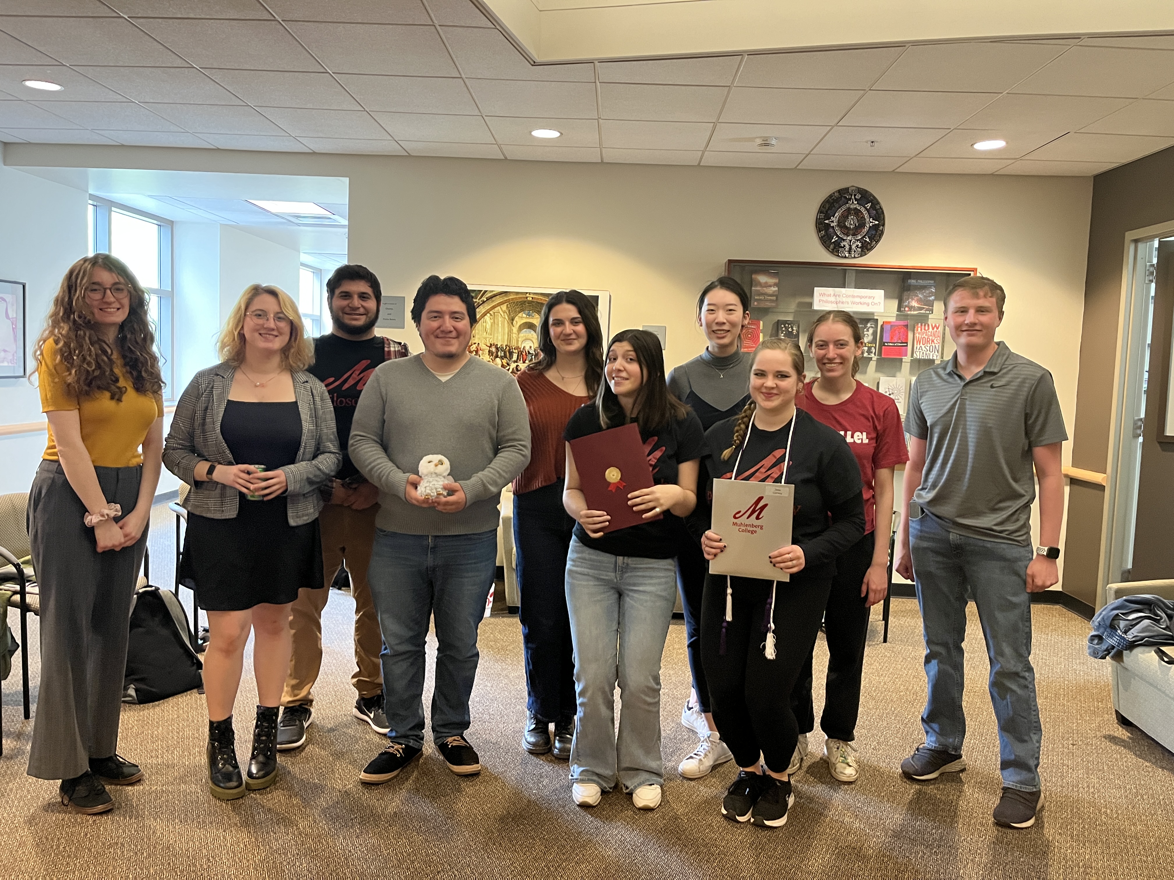 Group of students standing together posed in conference room setting.