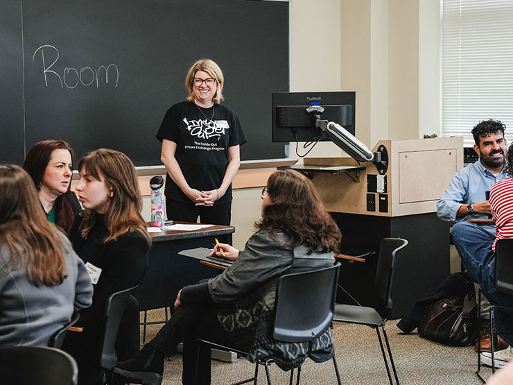 A college professor stands in front a classroom of students.
