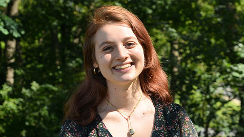 Smiling college student Sophie Tomov poses outdoors.