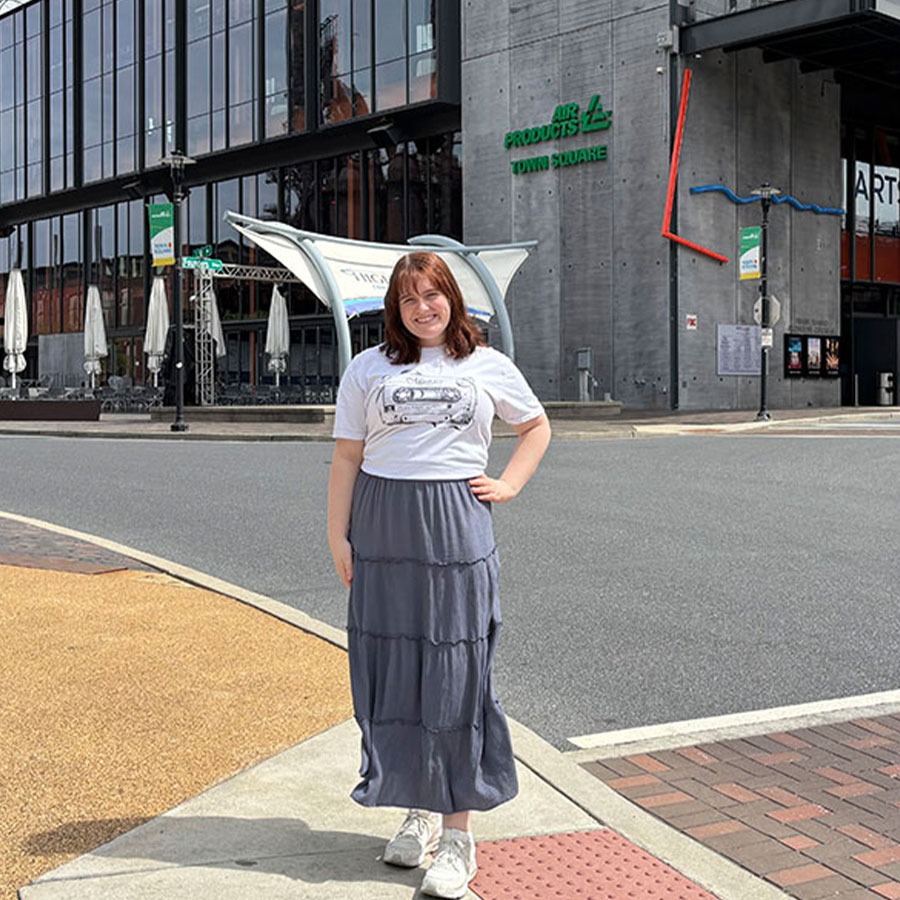 College student Marie Tohill stands, hands on hip, outside of the ArtsQuest building.