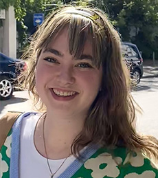 Hagar Avichai, Israel Fellow, standing outside on road in urban setting.