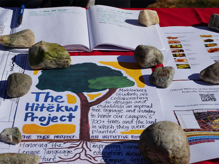 A table full of information about a tree tracking and Indigenous heritage project fill a table.