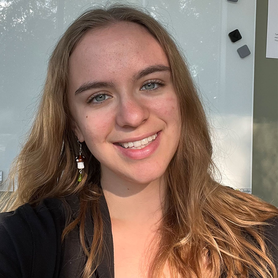 A young woman with shoulder-length blonde hair smiles at the camera.