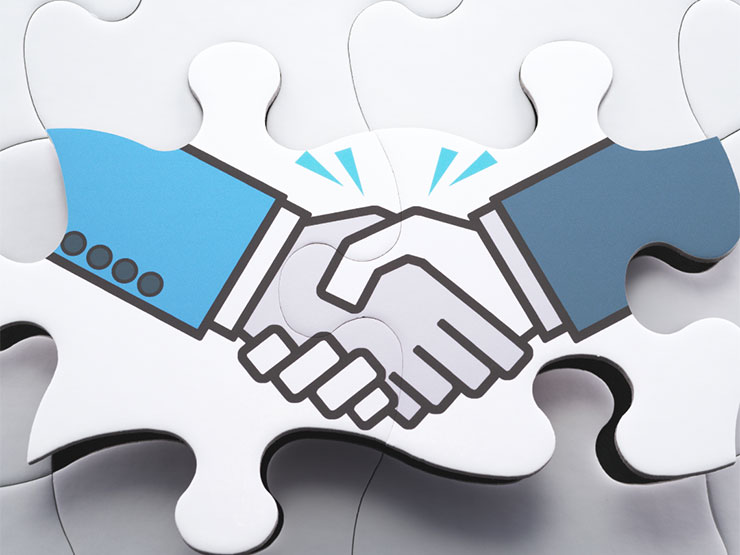 An illustration of a handshake on connected puzzle pieces.