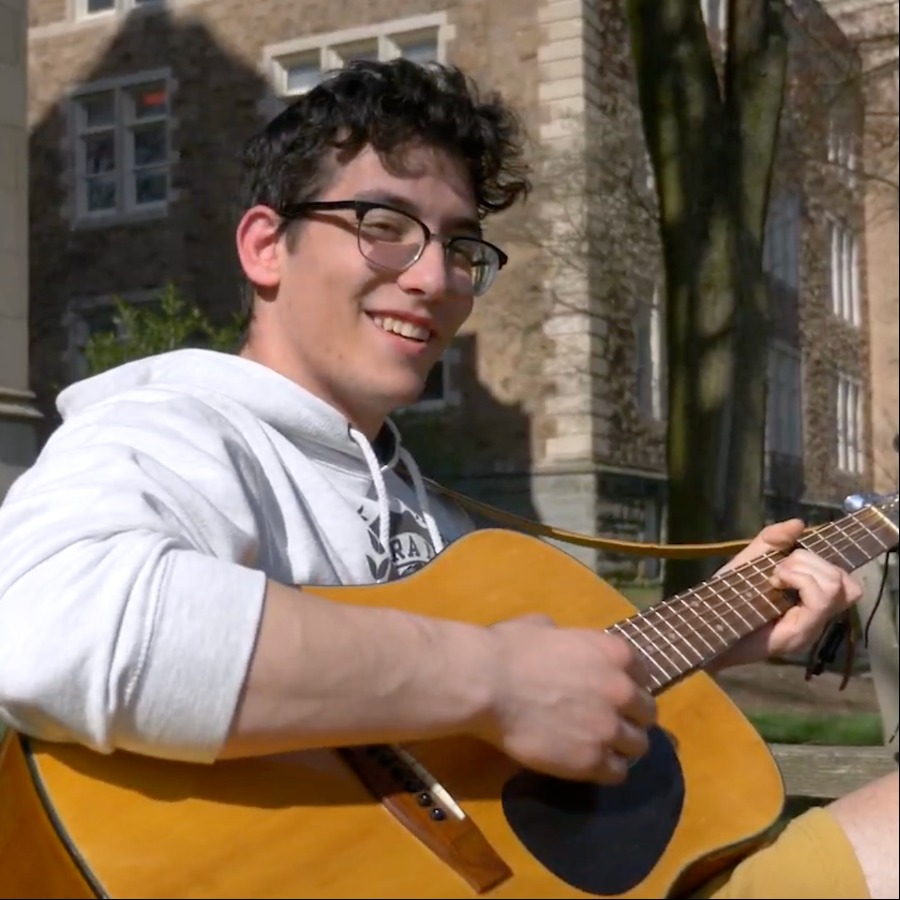Profile image of Sam Nulman, Finance and Business Administration major,  holding a guitar